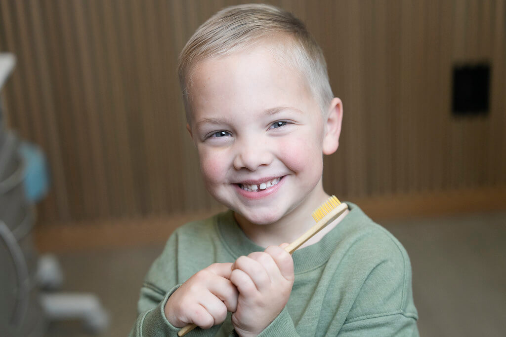 Happy boy holding toothbrush