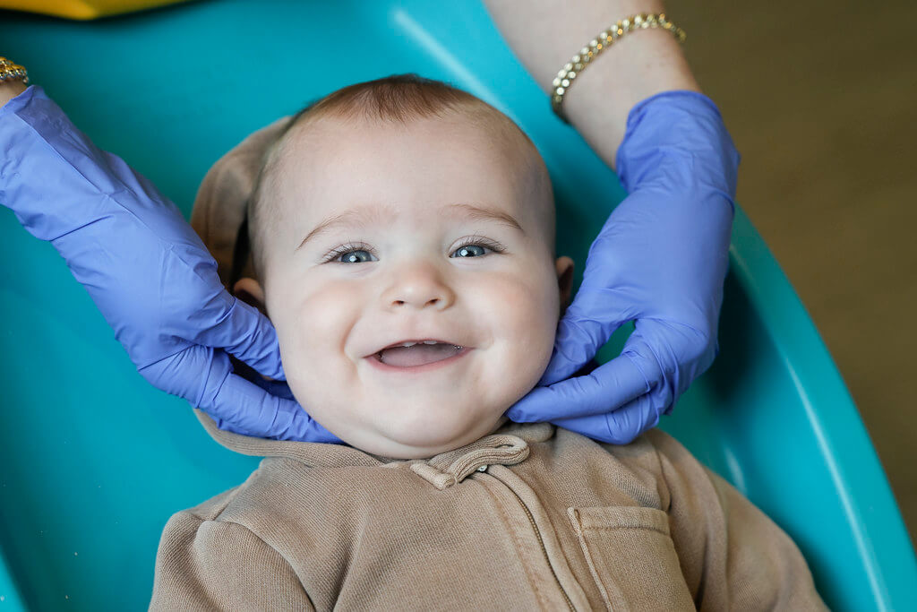 Baby smiling in pediatric dentists chair