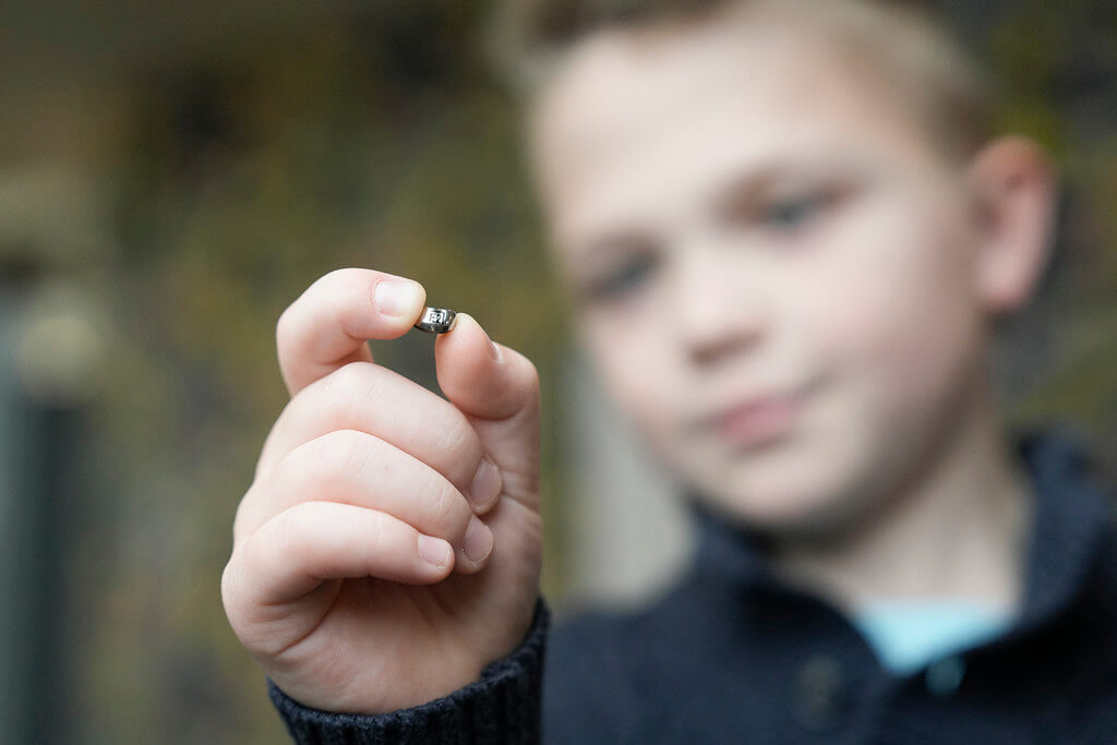 Boy holding silver tooth crown