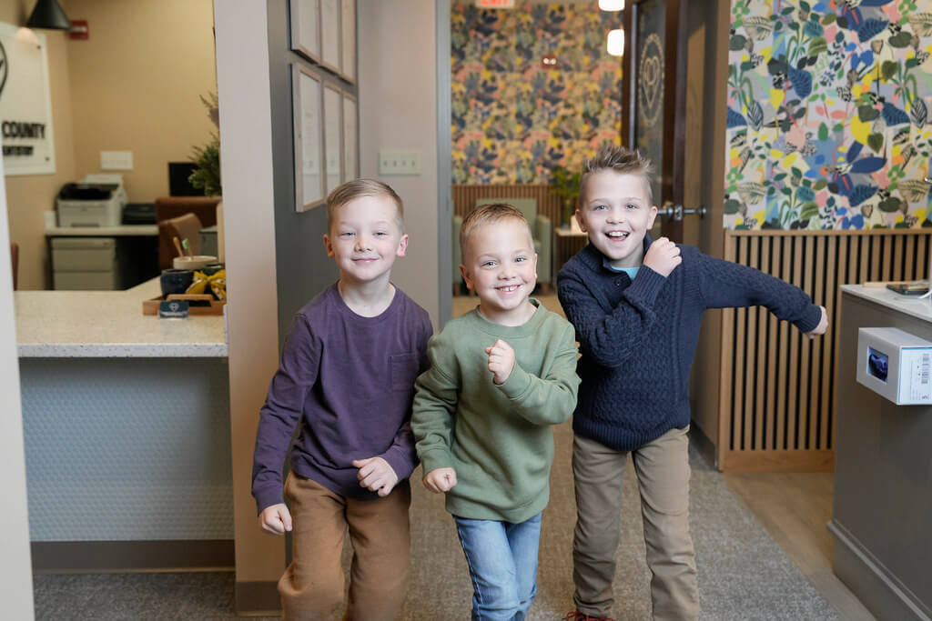 Boys running happily in dental office