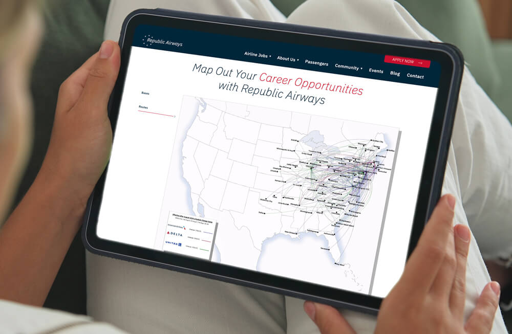 a tablet held by a person is displaying Republic Airways career page with a large map of the United States and multiple flight paths